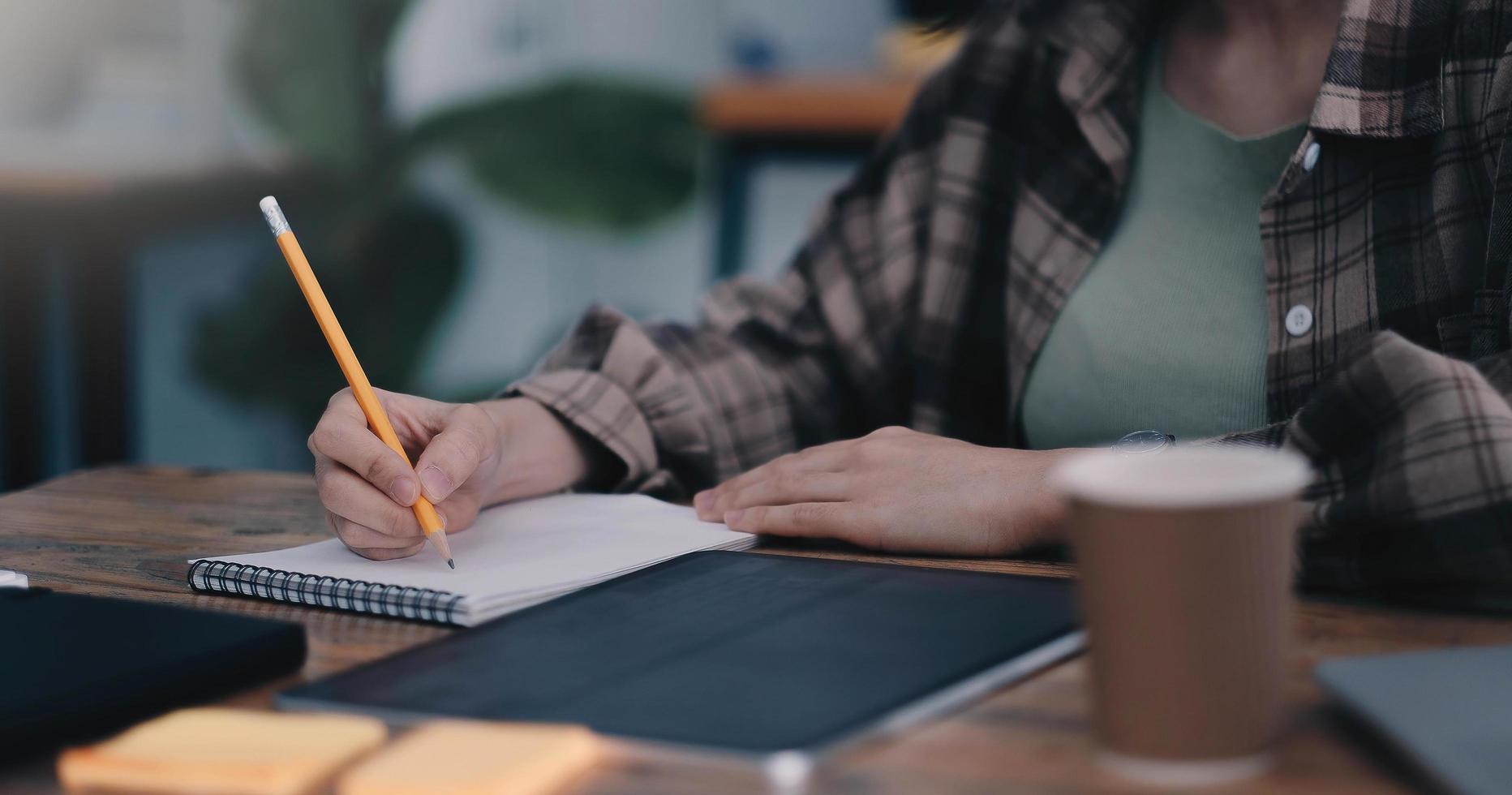 lezione online, studente che scrive sul taccuino mentre studia a casa foto