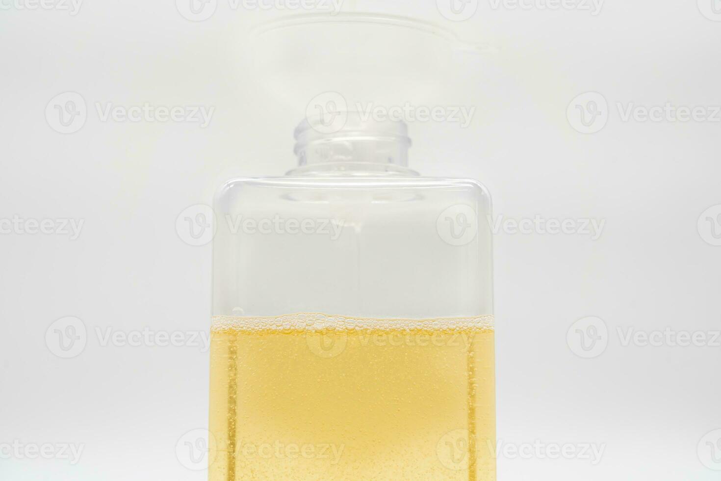 versare giallo liquido attraverso un' imbuto. riempire un' distributore con liquido sapone o shampoo di scrosciante esso a partire dal un' ricarica per ridurre plastica sciupare. sostenibile zero rifiuto foto