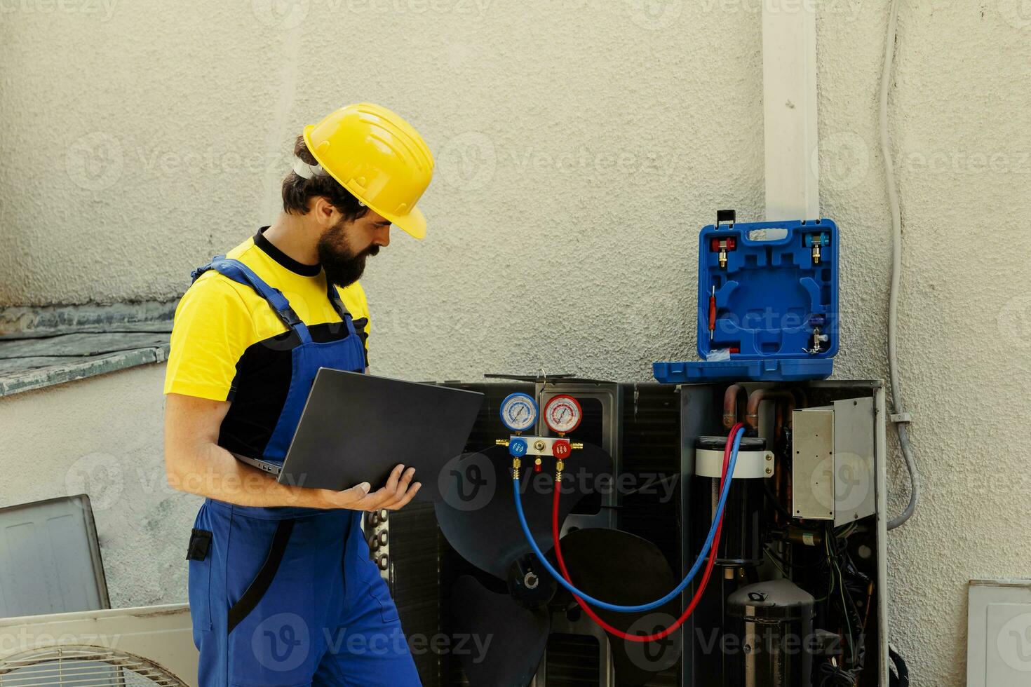 allenato ingegnere incaricato con manutenzione all'aperto aria condizionatore interno componenti, controllo freon livello e calibrare termostati. qualificato tecnico guardare al di sopra di Manutenzione Piano su il computer portatile foto