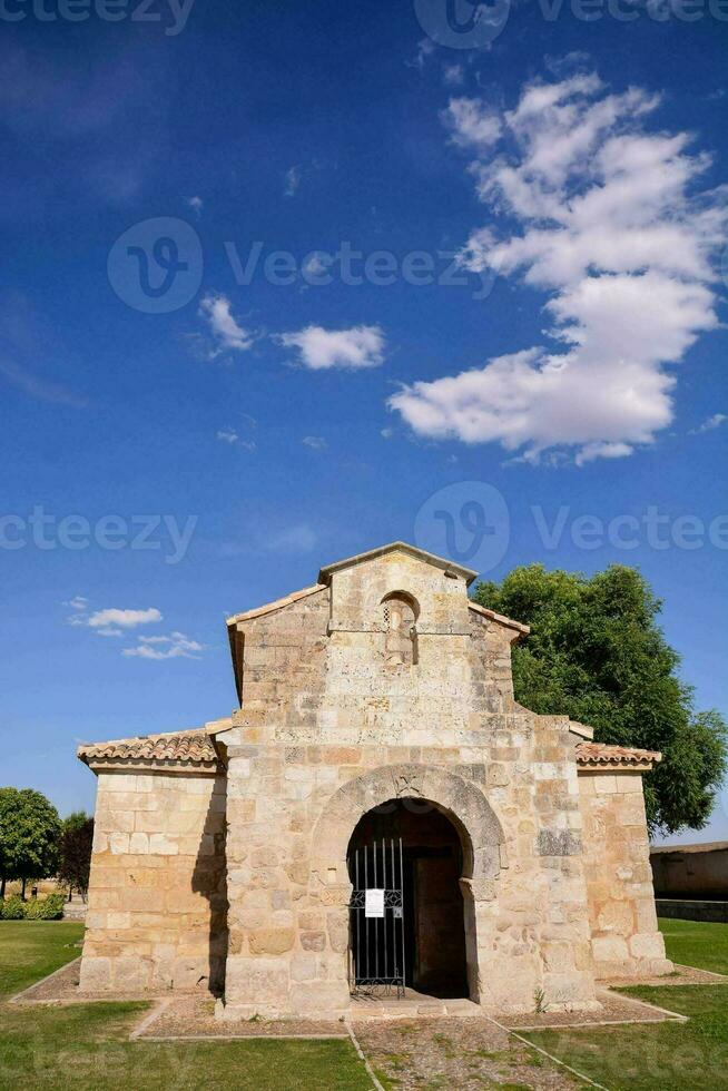 un' piccolo pietra Chiesa con un' blu cielo e nuvole foto