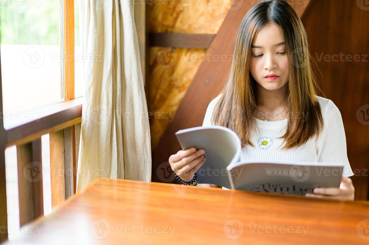 bella donna seduta in un bar a leggere un libro foto