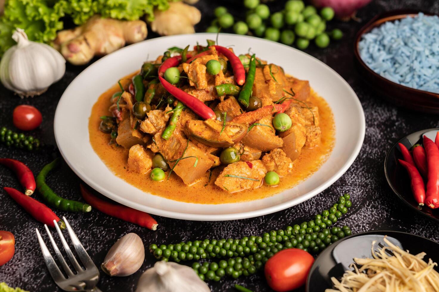 curry rosso con carne di maiale in un piatto bianco foto