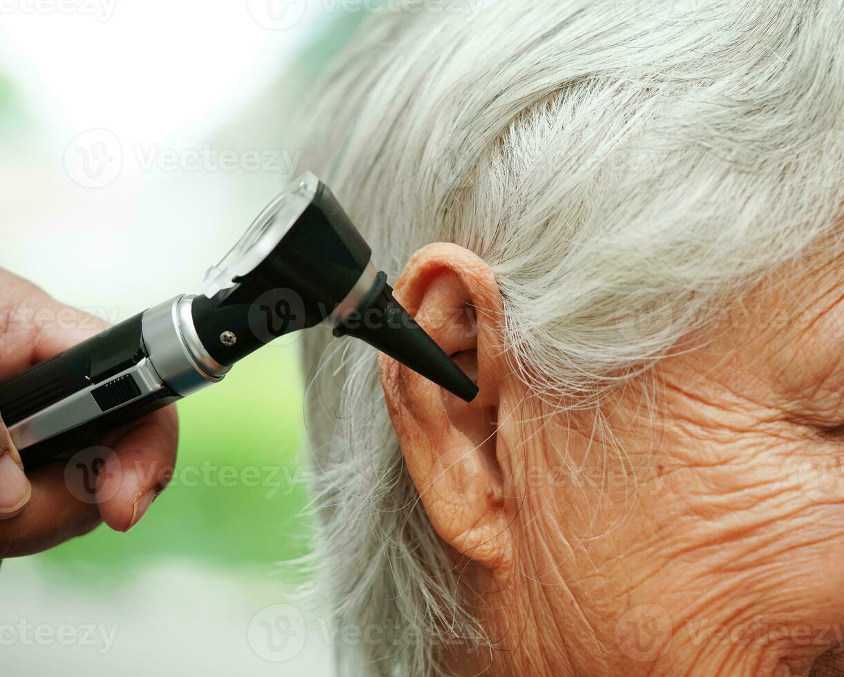 otorinolaringoiatra o ent medico medico l'esame anziano paziente orecchio con otoscopio, udito perdita problema. foto