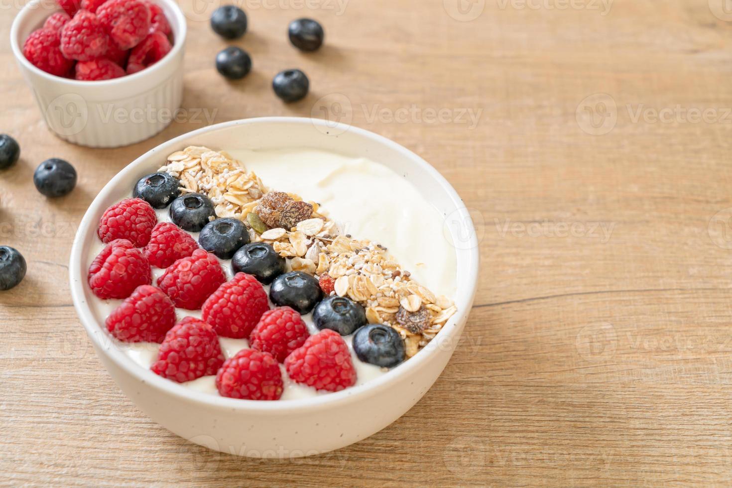 ciotola di yogurt fatta in casa con lamponi, mirtilli e muesli foto