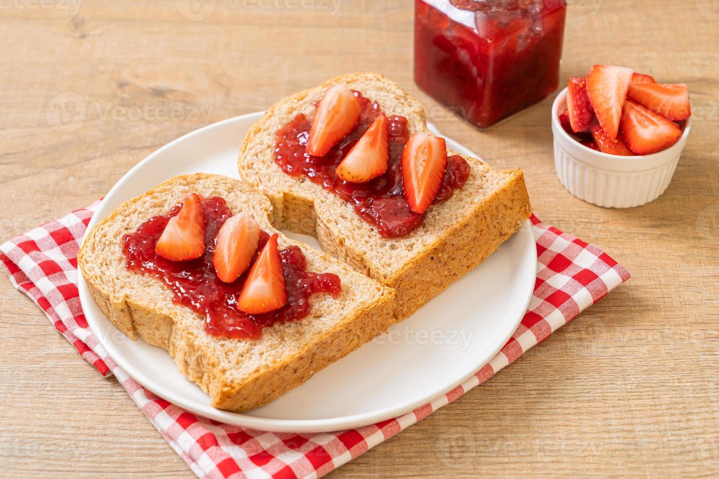 pane integrale con marmellata di fragole e fragole fresche foto