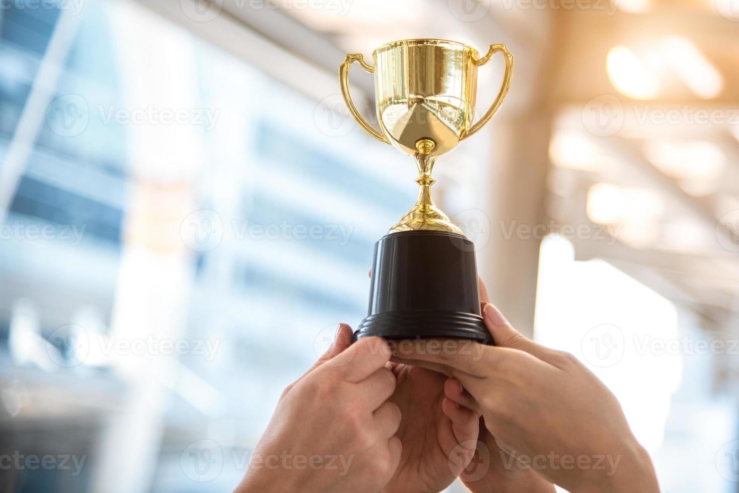 campione trofeo d'oro per il vincitore con le mani del giocatore sportivo foto