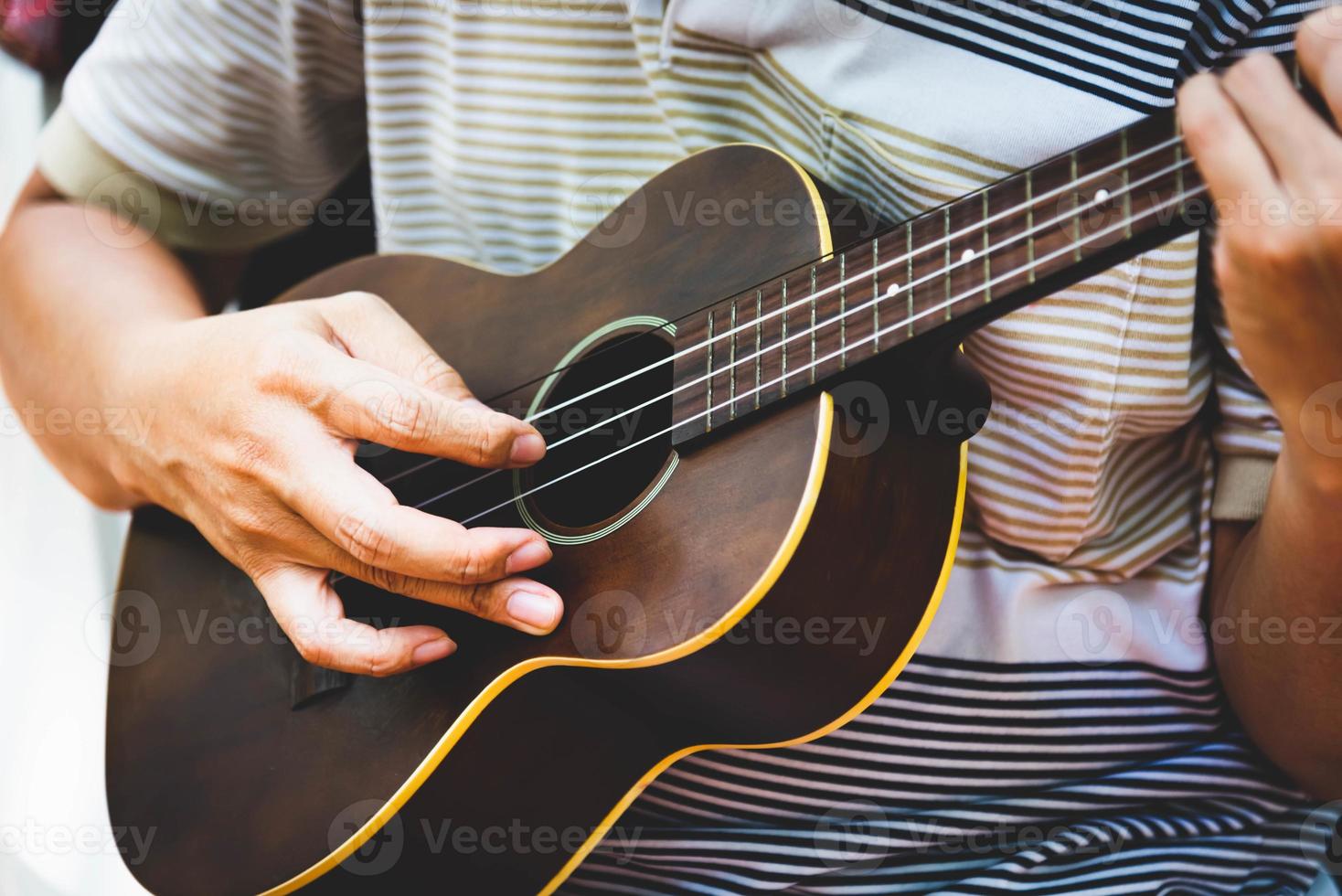 primo piano della mano del chitarrista che suona la chitarra. concetto di strumento musicale foto