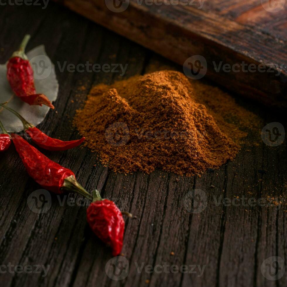 spezie e stagionatura. caldo terra chili Pepe stagionatura con secco rosso peperoni su un' di legno Marrone buio sfondo foto