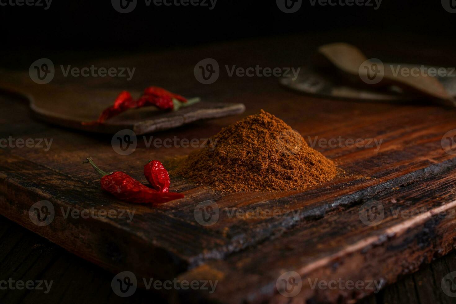 caldo erbe aromatiche e spezie. rosso terra chili peperoni con secco peperoni su un' di legno Marrone tavola su un' buio sfondo foto