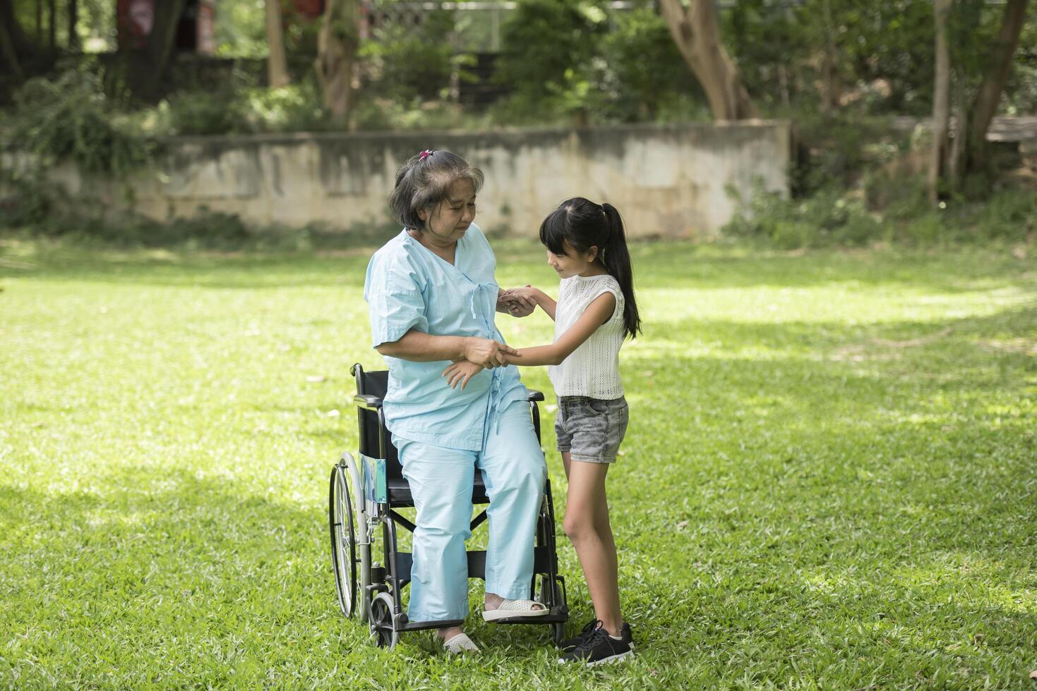 nonna anziana in sedia a rotelle con nipote in ospedale foto