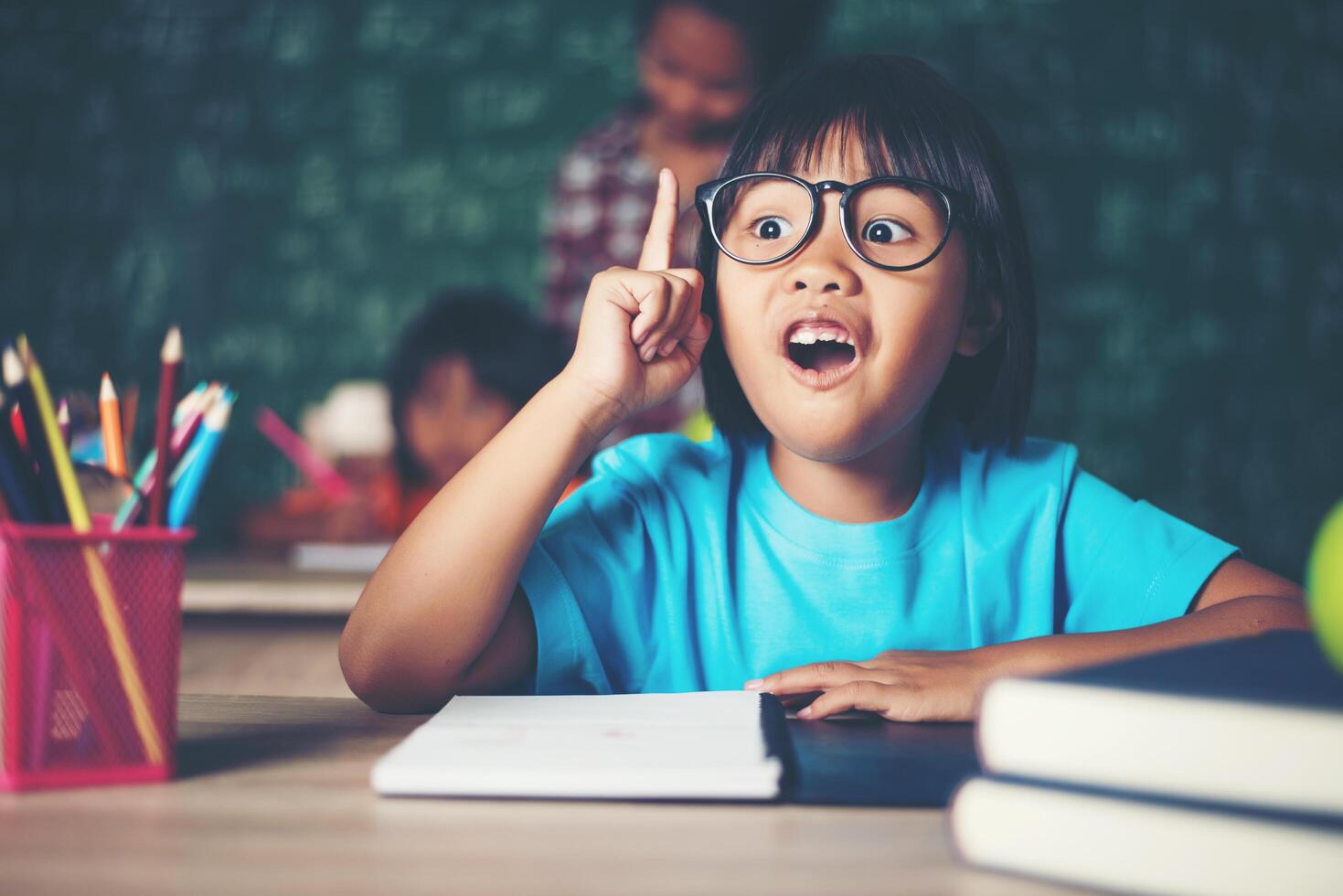 bambina premurosa con libro vicino a un consiglio scolastico foto