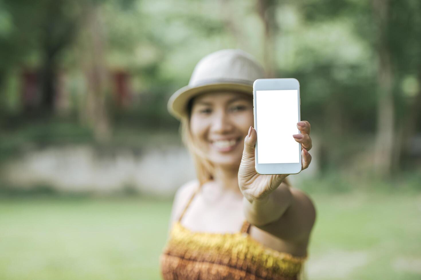 mano della donna che tiene il cellulare, smartphone con schermo bianco foto