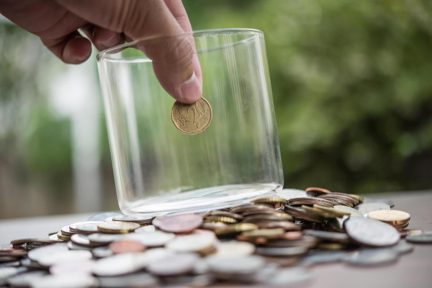 concetto di risparmio di denaro. mano che mette la pila di monete dei soldi foto