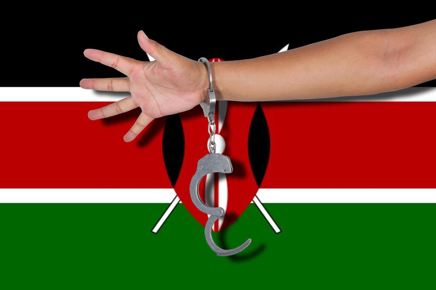 manette con la mano sulla bandiera del kenya foto