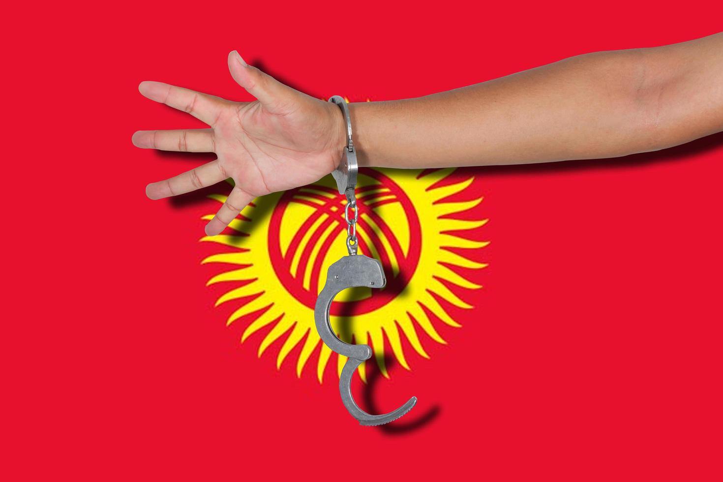 manette con la mano sulla bandiera del Kirghizistan foto