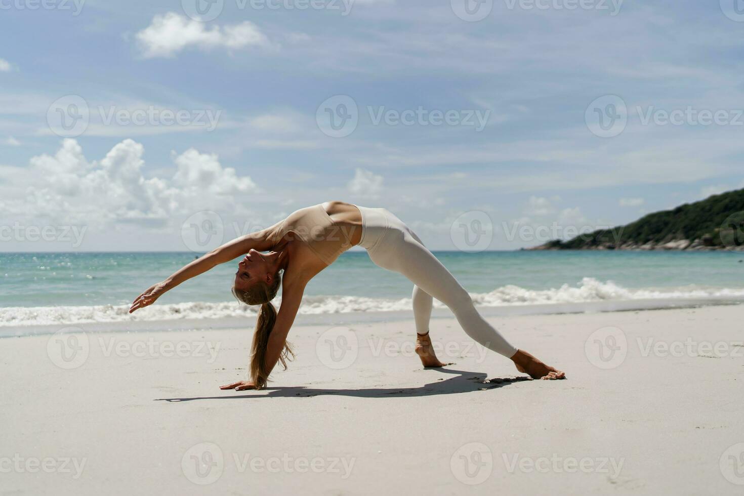 grazioso donna indossare bianca abbigliamento sportivo praticante yoga su spiaggia nel Tailandia. sensazione così confortevole e rilassare nel vacanza, sano concetto. foto