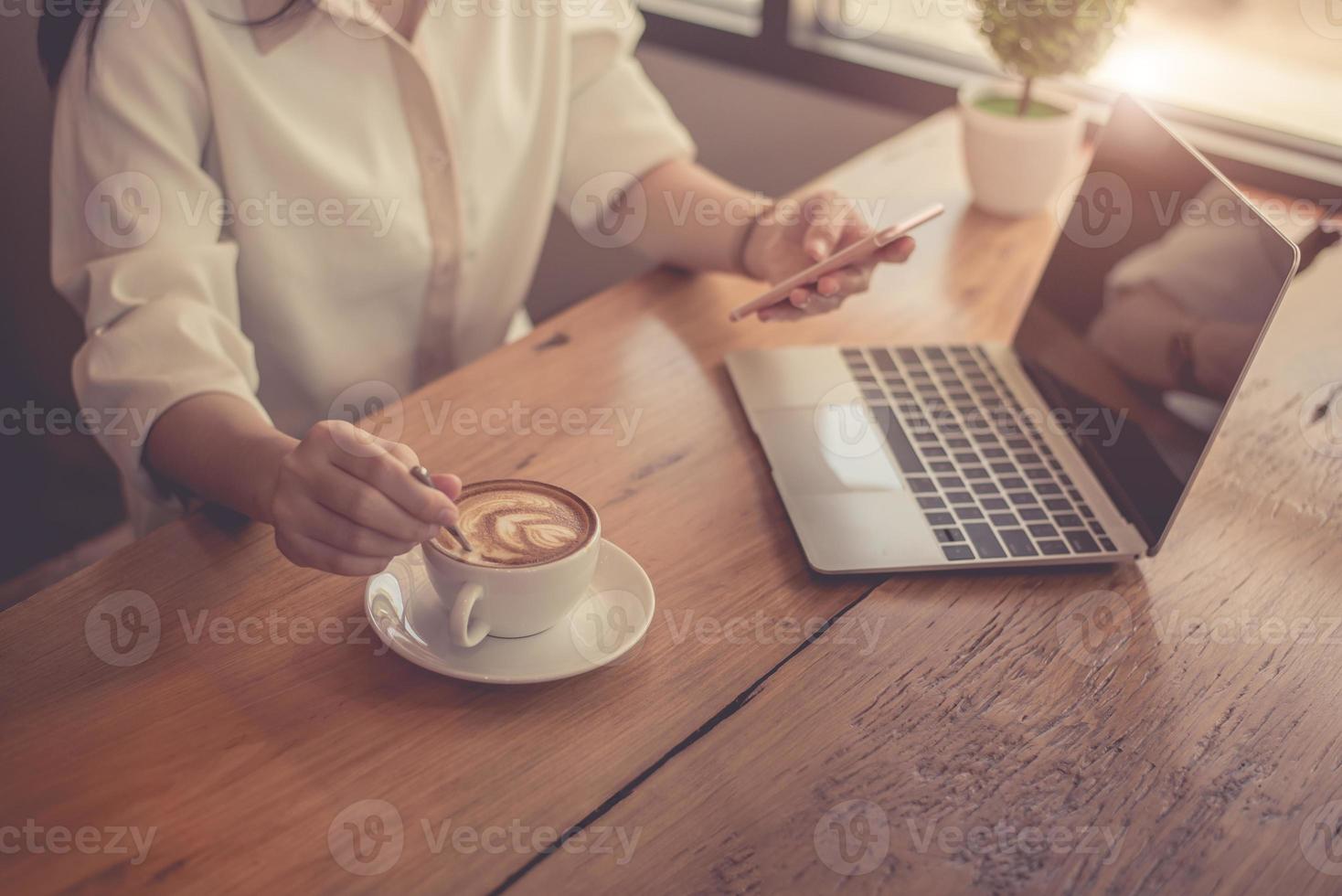 primo piano di una donna d'affari che lavora con il laptop e beve caffè foto