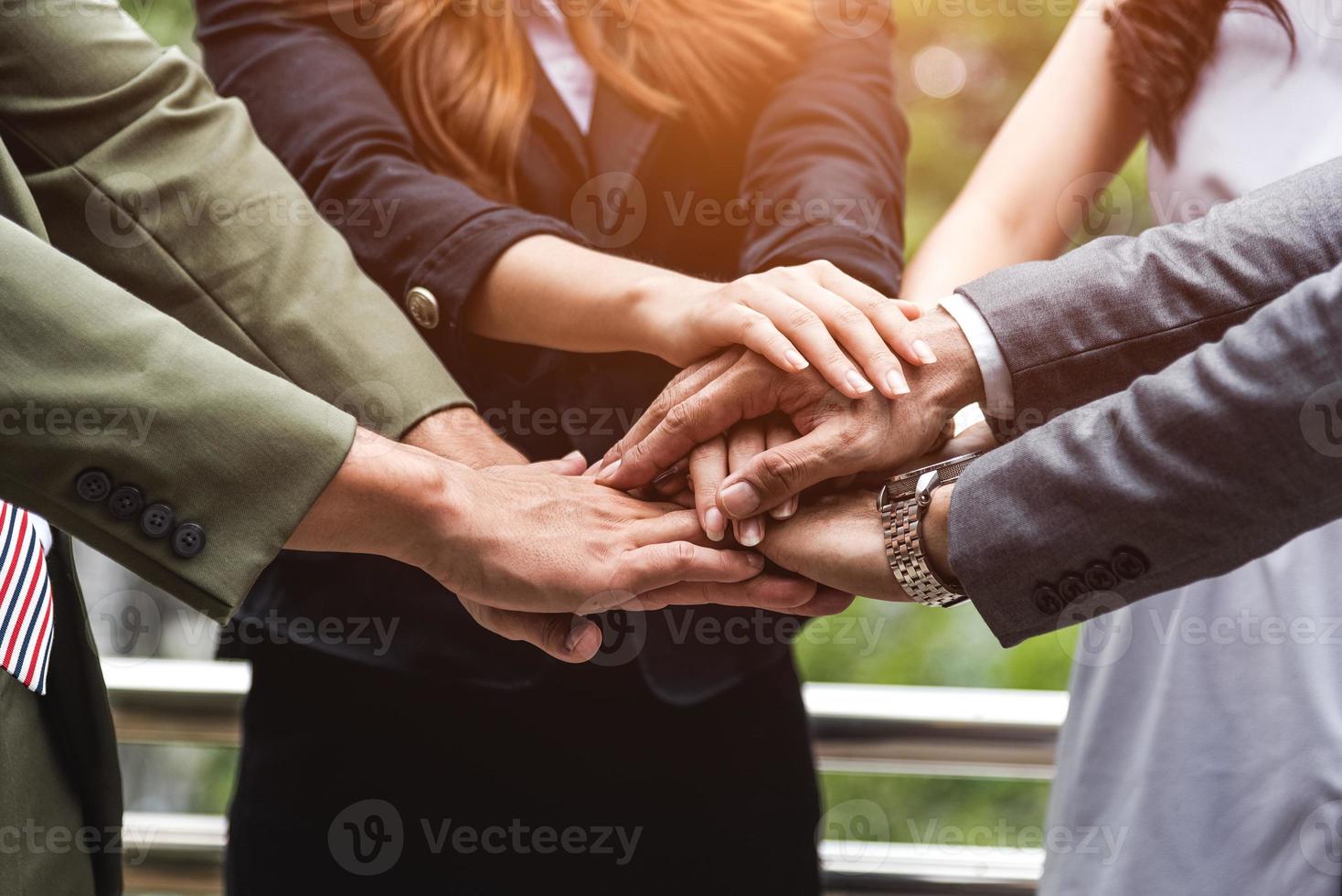 primo piano di uomini d'affari che si impilano le mani come leadership del lavoro di squadra foto