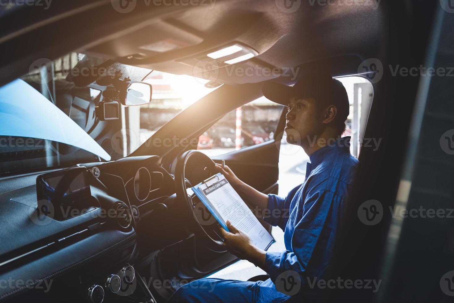 meccanico che tiene appunti e controlla all'interno dell'auto foto