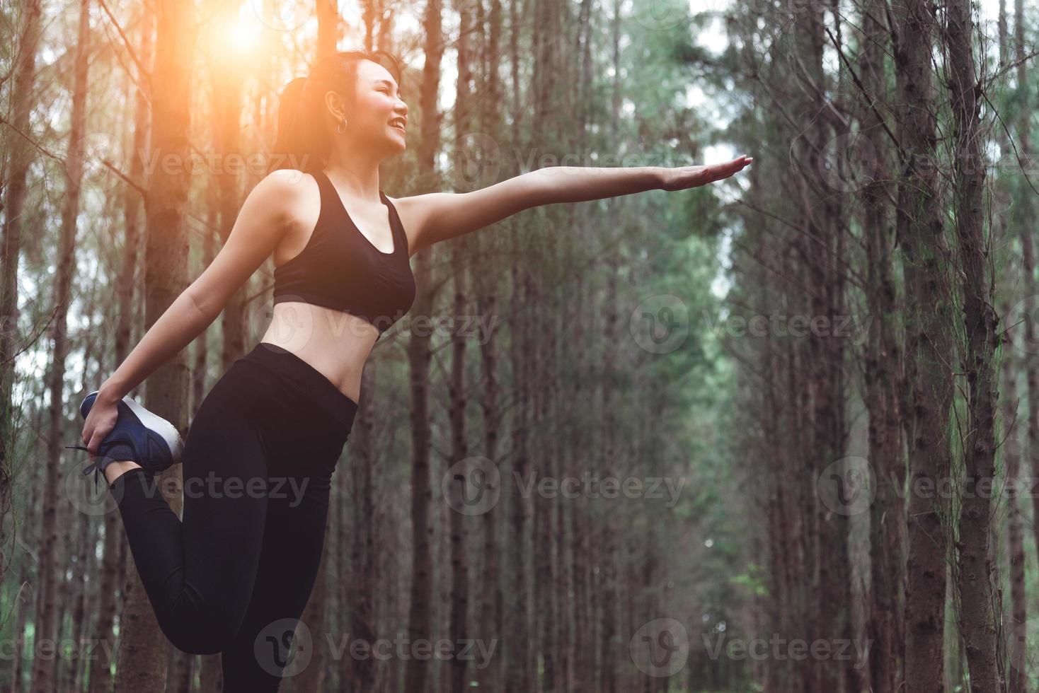 bellezza donna asiatica che fa yoga e allunga le gambe prima di correre foto