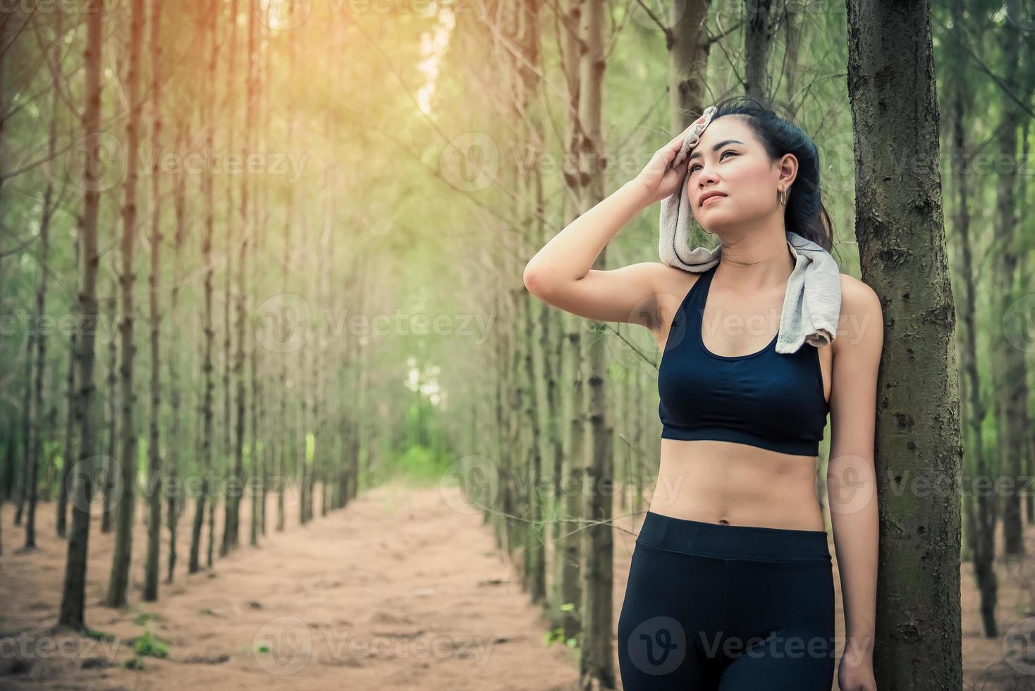 donna asiatica di bellezza che asciuga il sudore nella foresta foto