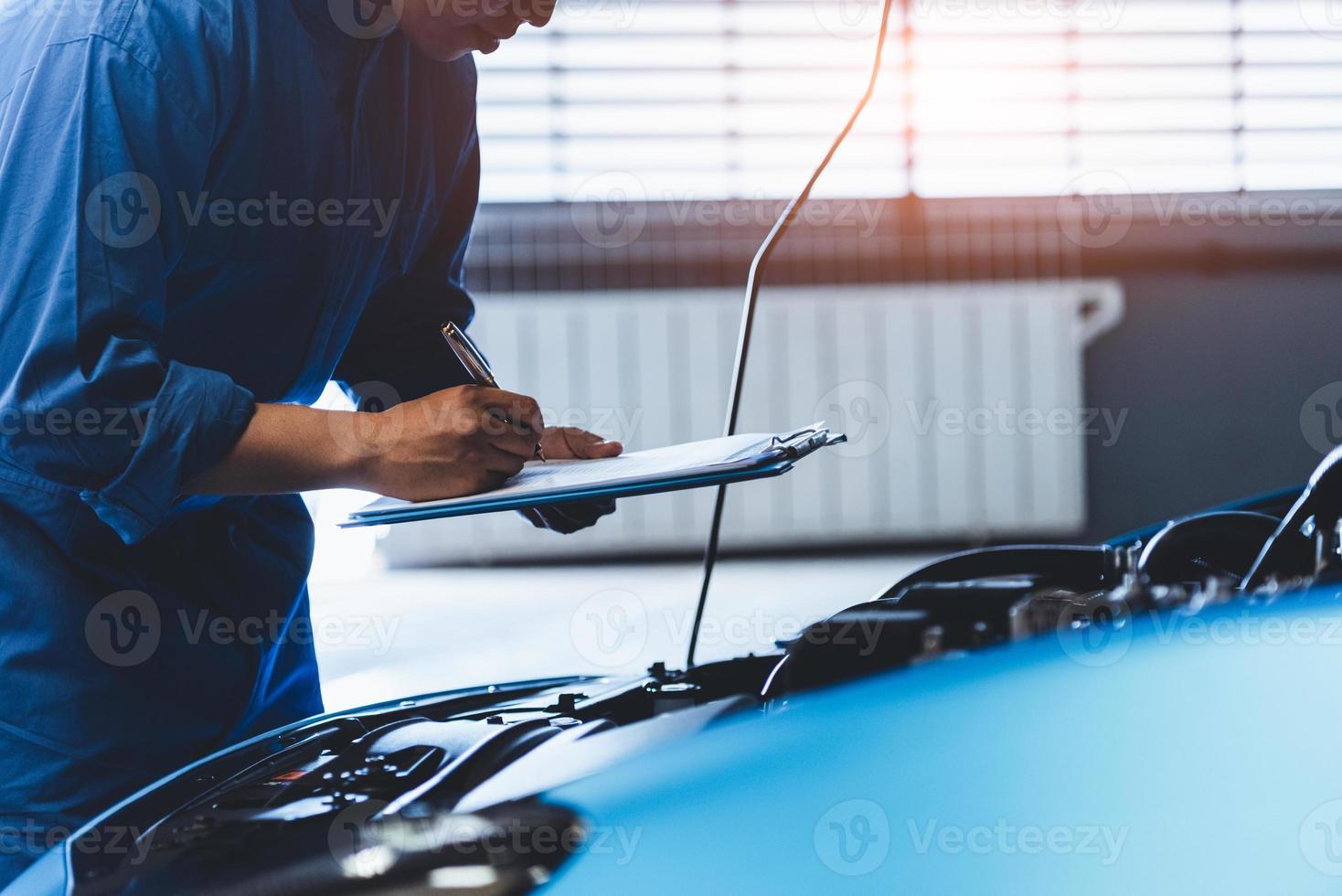 meccanico di auto che controlla il reclamo del cliente del veicolo di manutenzione foto