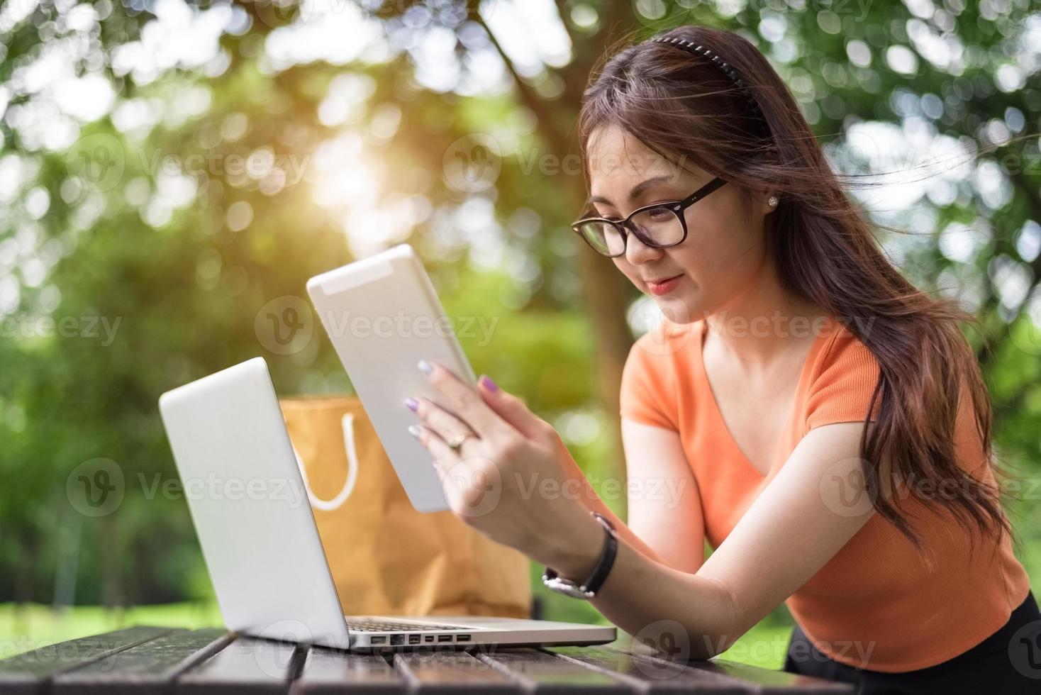 bellezza donna asiatica che utilizza tablet nel parco? foto