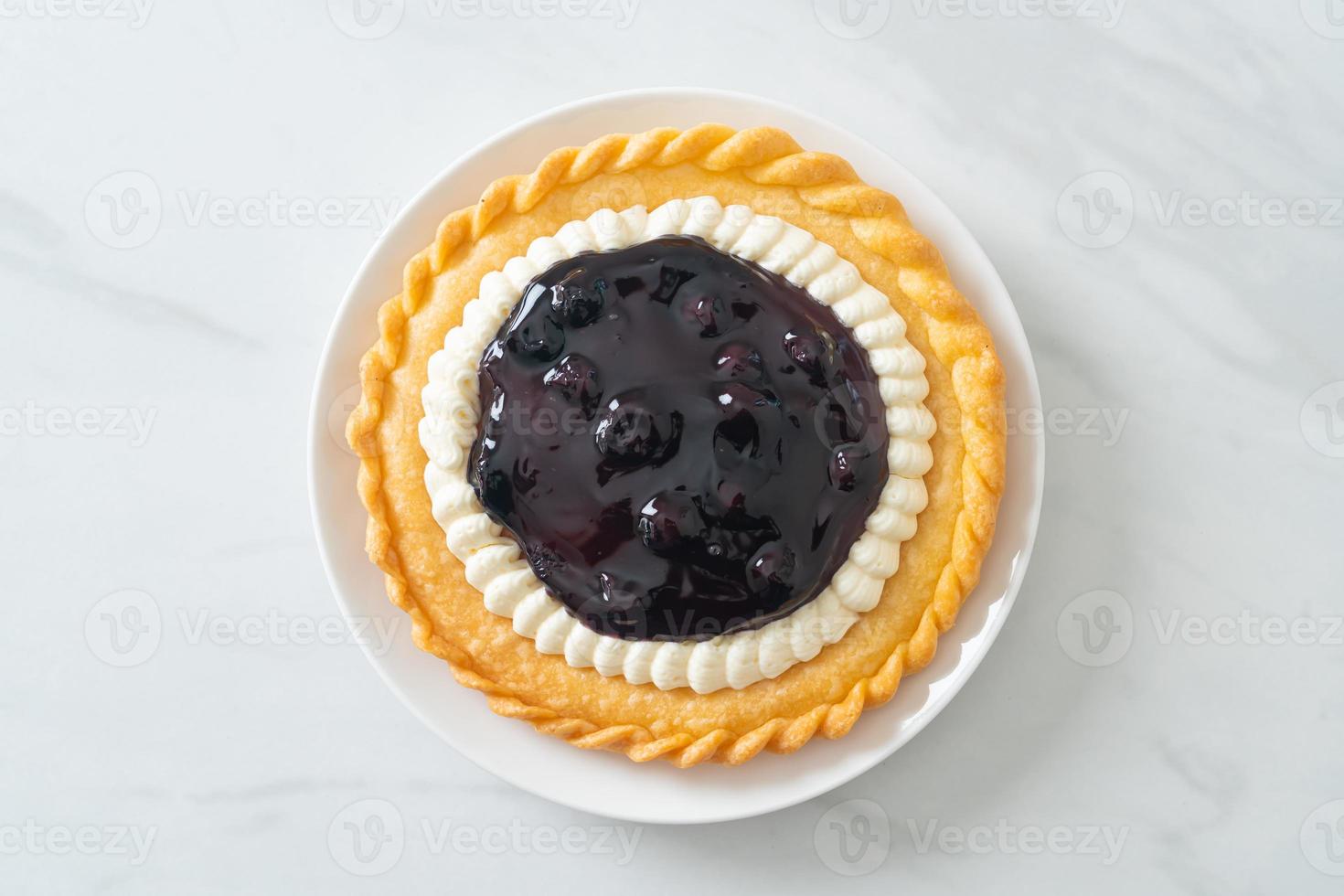 torta di formaggio ai mirtilli su piatto bianco foto