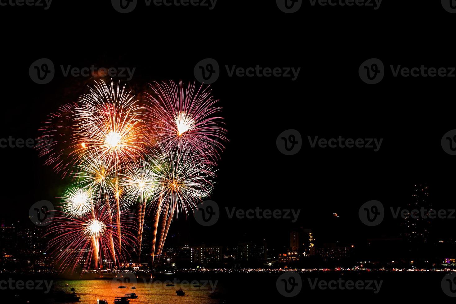 molti fuochi d'artificio lampeggianti con paesaggio urbano notturno. foto