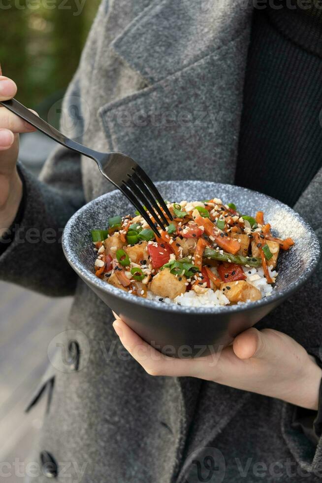 donna mangiare gustoso Riso, carne e verdure con forchetta, avvicinamento foto