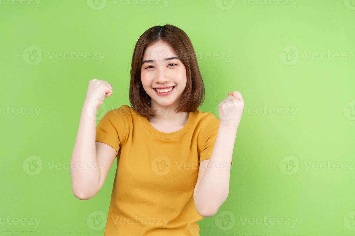 giovane ragazza asiatica in posa su sfondo verde foto