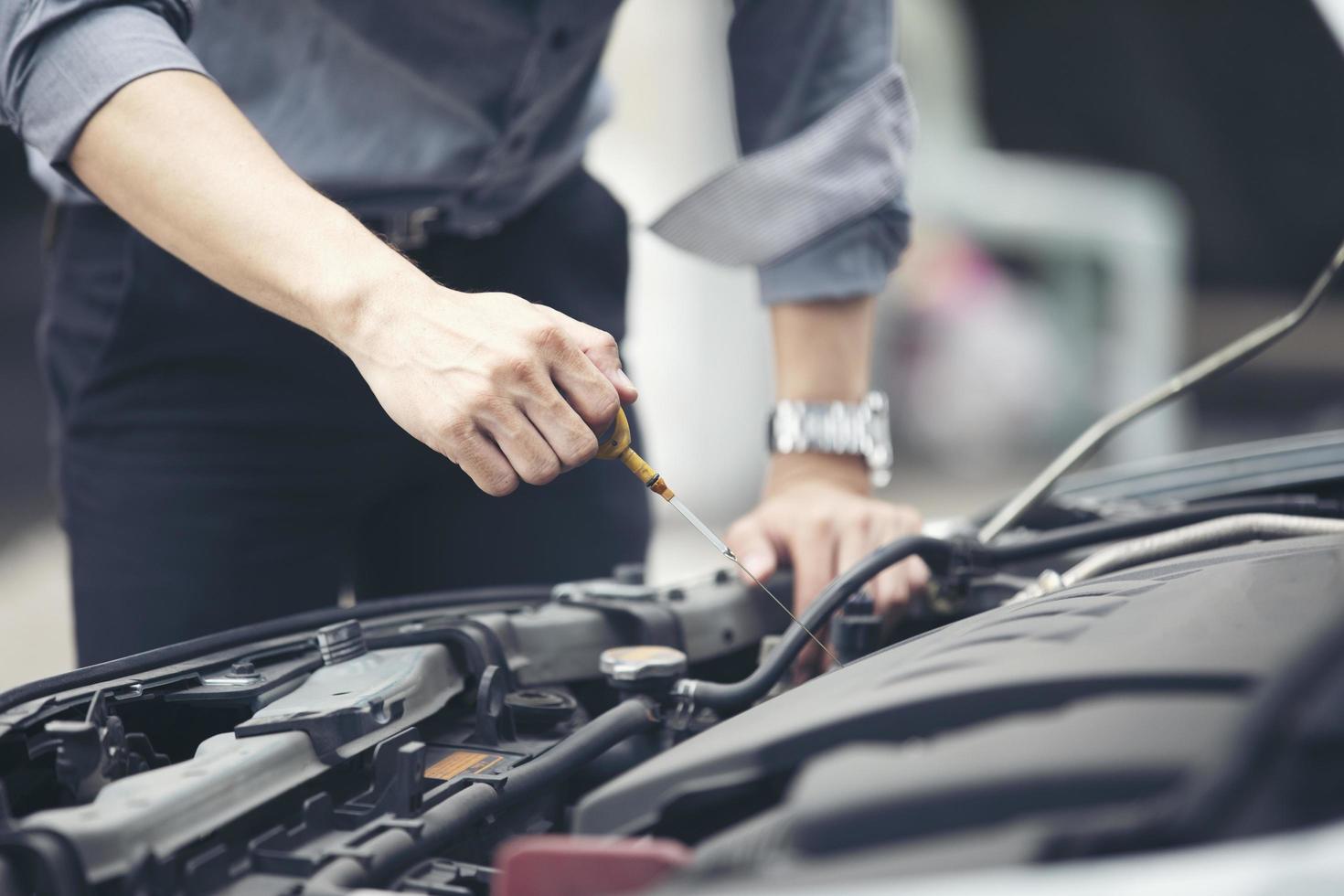 uomo che controlla il motore di un'auto foto