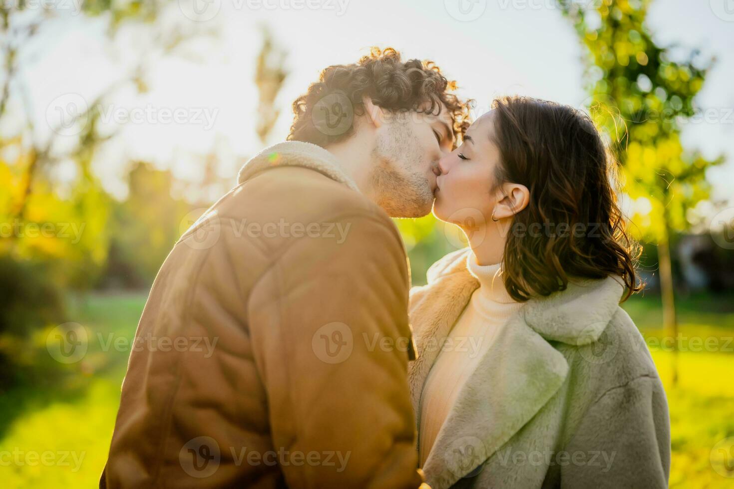 contento amorevole coppia baci nel parco nel tramonto. foto