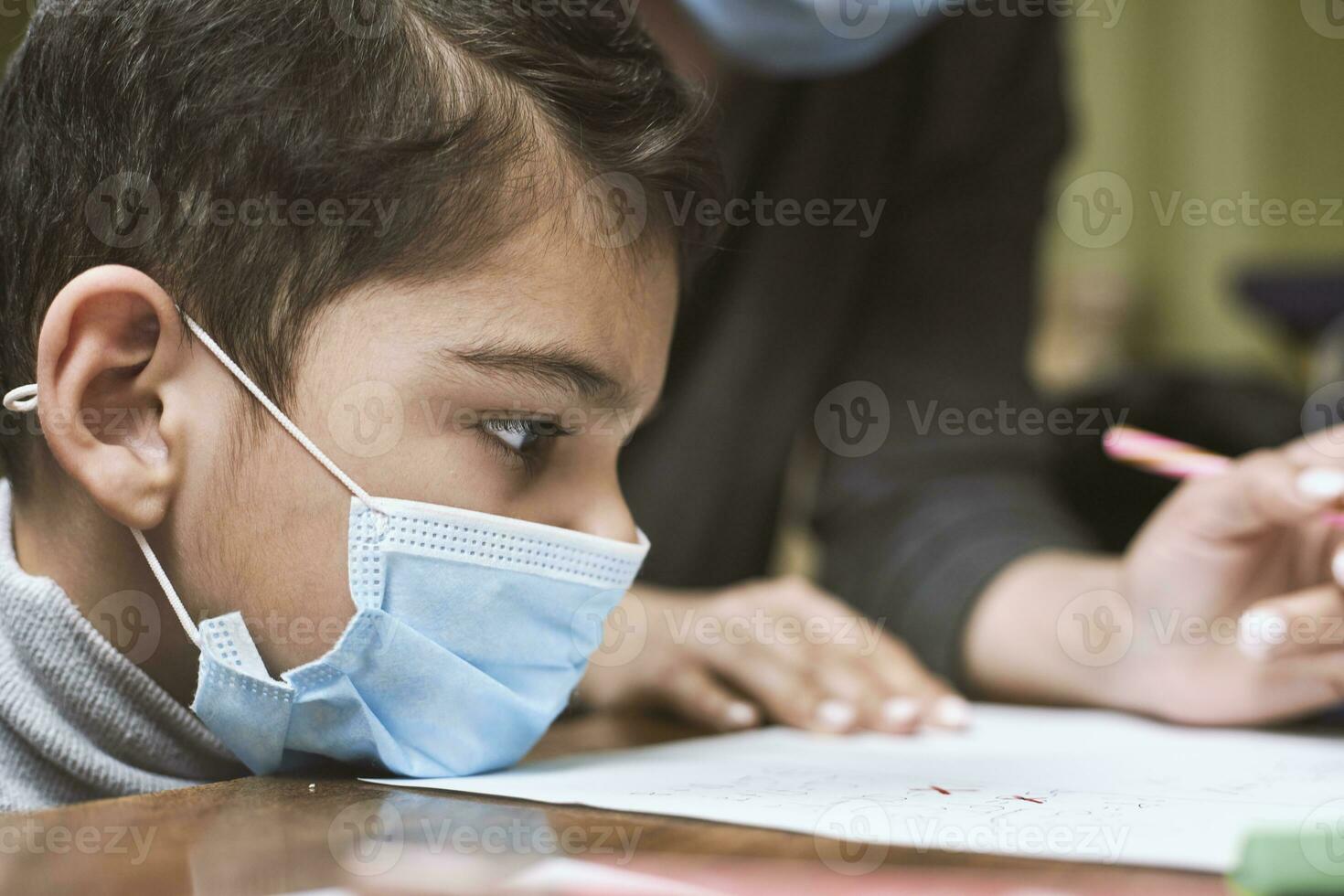 distanza formazione scolastica. madre aiuta un' scuola materna ragazzo per fare Lezioni foto