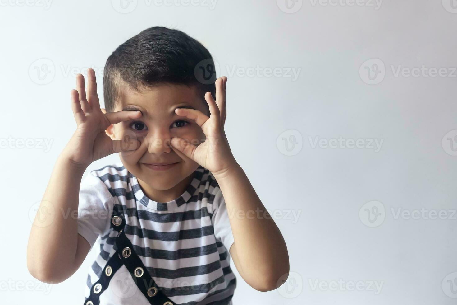 sei anni ragazzo ritratto. innocente sorridente poco ragazzo su grigio sfondo. poco ragazzo contorti il suo viso. le persone, infanzia stile di vita concetto. foto