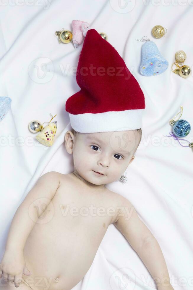 9 mese bambino ragazzo con Santa Claus cappello. Natale mattina. poco ragazzo giocando. foto