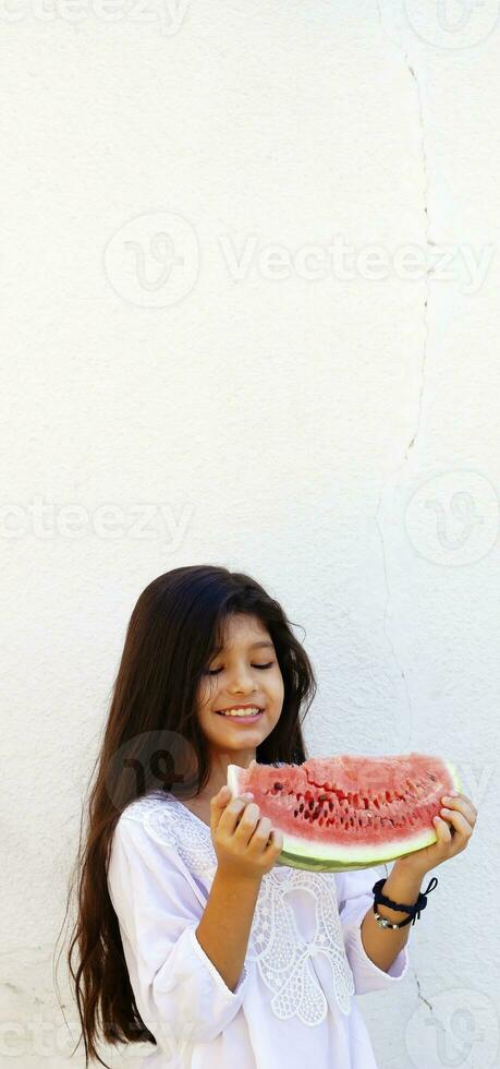 pre-teen ragazza mangiare anguria. contento infanzia. estate ragazza. foto