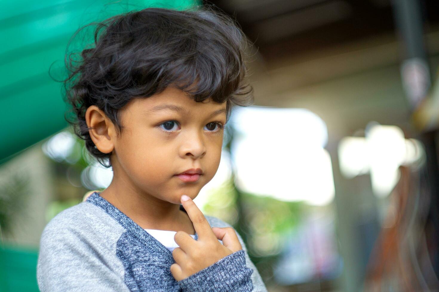 asiatico ragazzo sembra inoltrare e fa un idea. foto