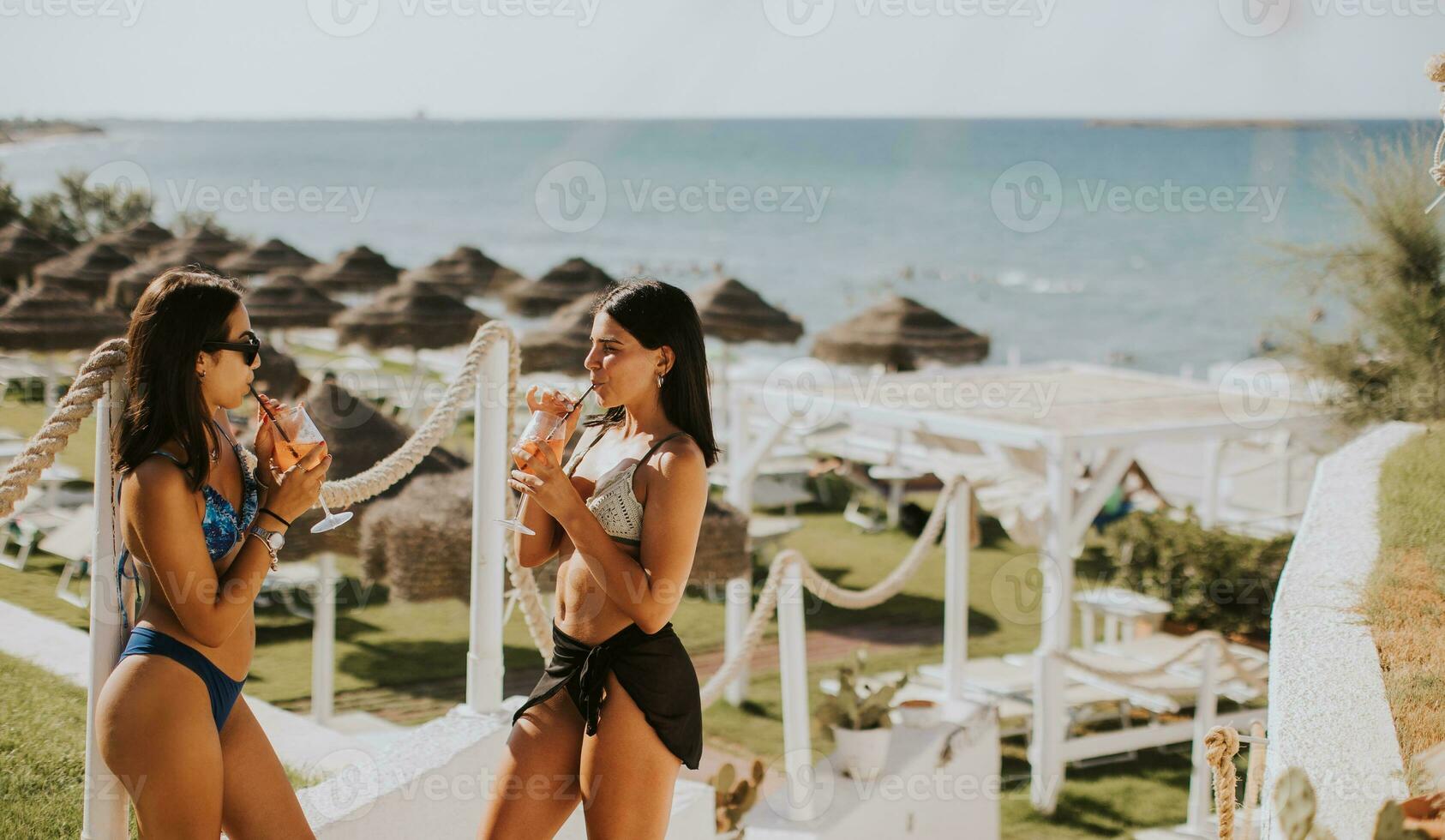 sorridente giovane donne nel bikini godendo vacanza su il spiaggia foto