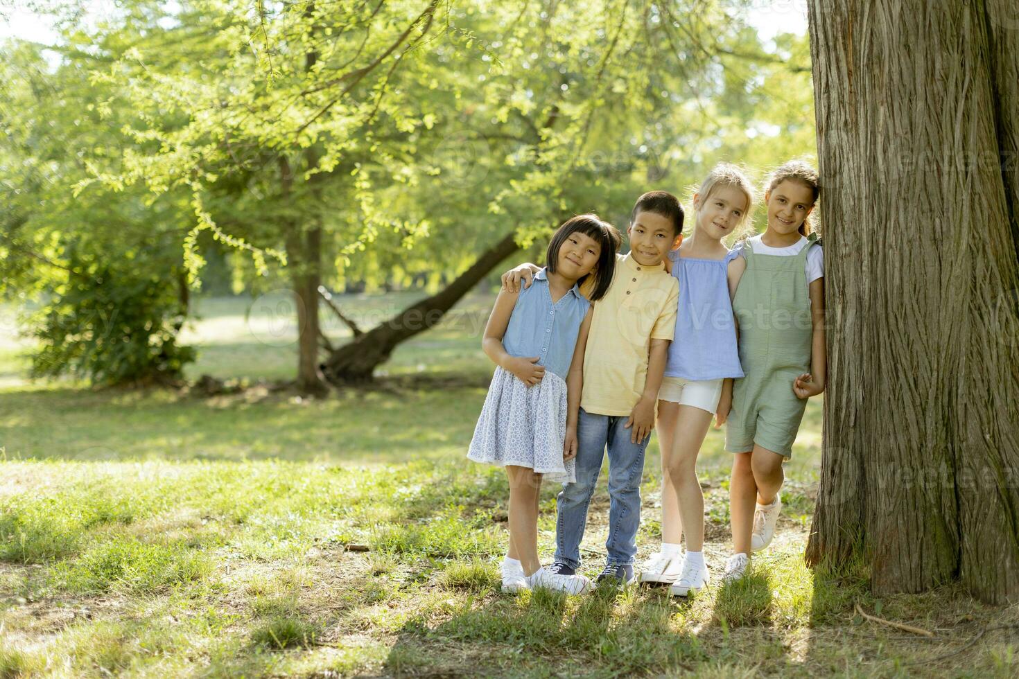 gruppo di asiatico e caucasico bambini avendo divertimento nel il parco foto