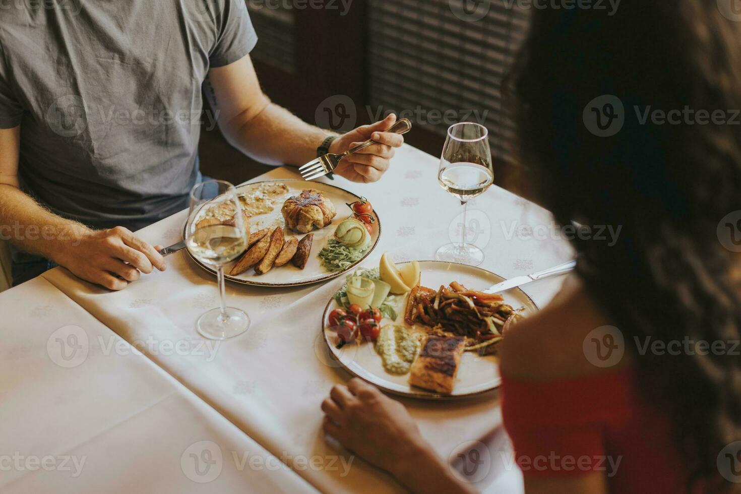 giovane coppia avendo pranzo con bianca vino nel il ristorante foto