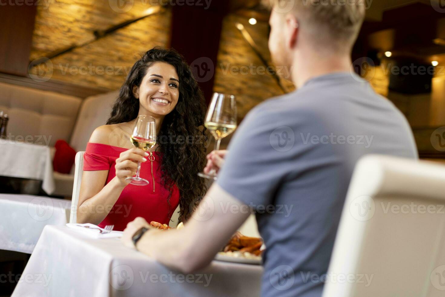 giovane coppia avendo pranzo con bianca vino nel il ristorante foto