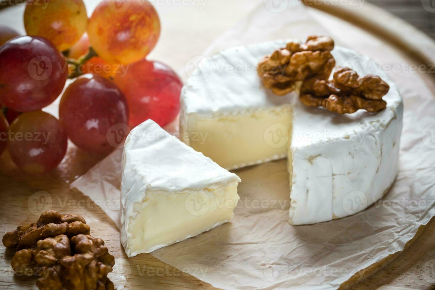 Camembert formaggio con Noci e uva foto