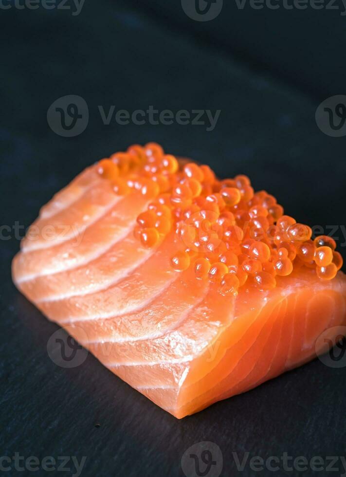 salmone con rosso caviale su il nero pietra tavola foto