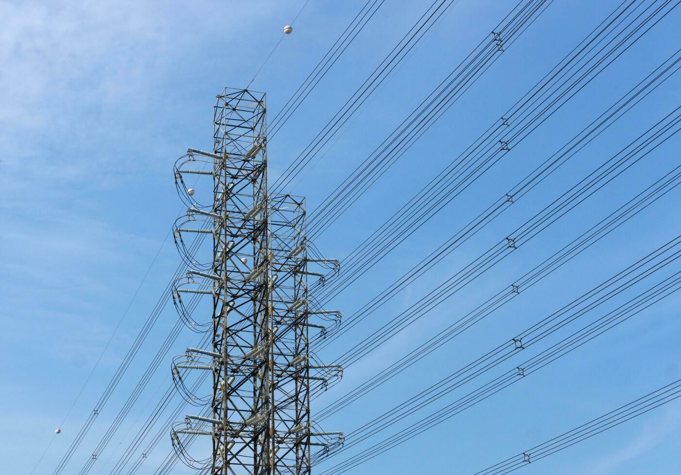 alta tensione di energia trasmissione torri su blu cielo sfondo foto