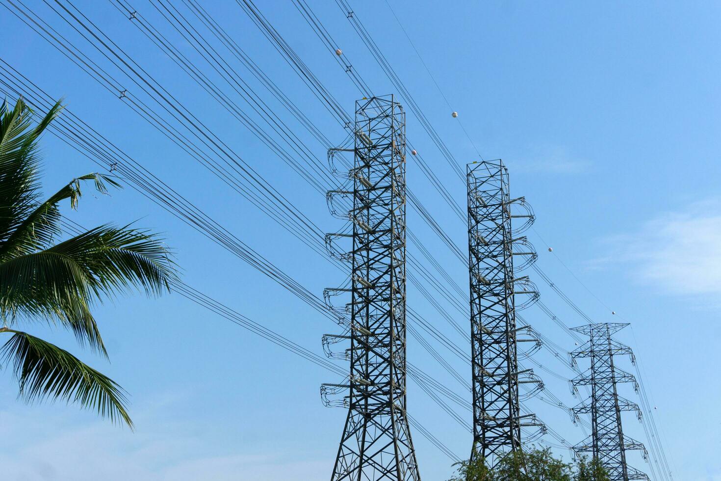 alta tensione di energia trasmissione torri su blu cielo sfondo foto