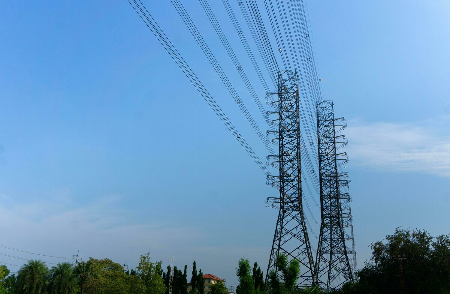 alta tensione di energia trasmissione torri su blu cielo sfondo foto