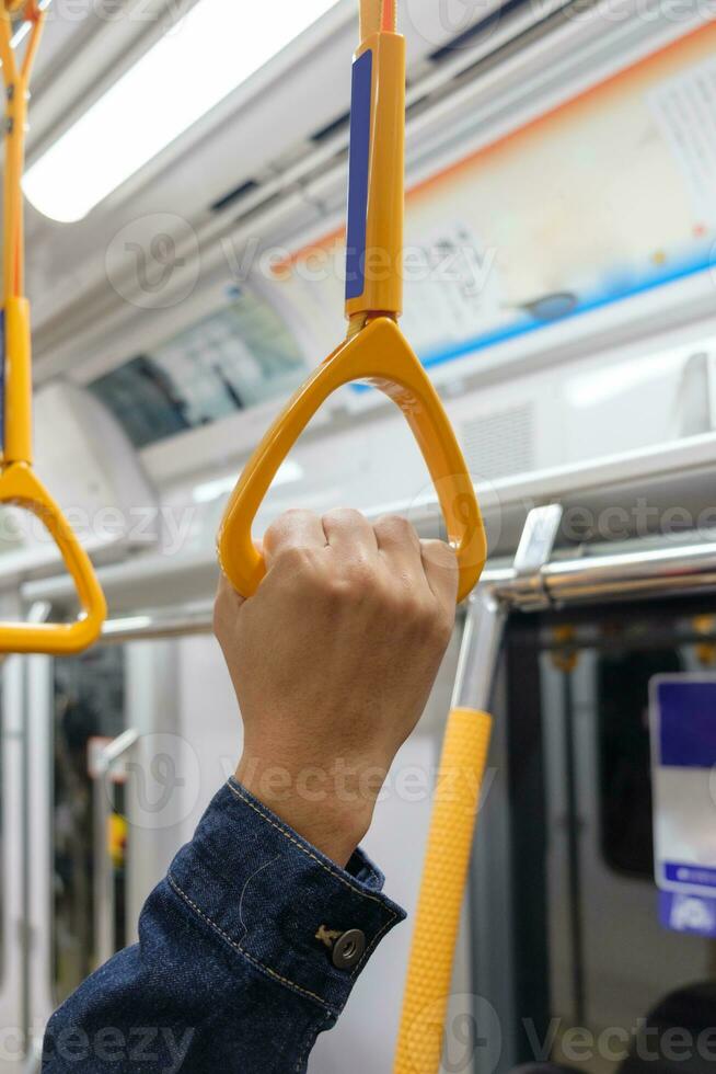 turista uomo mano Tenere un' corrimano di treno foto