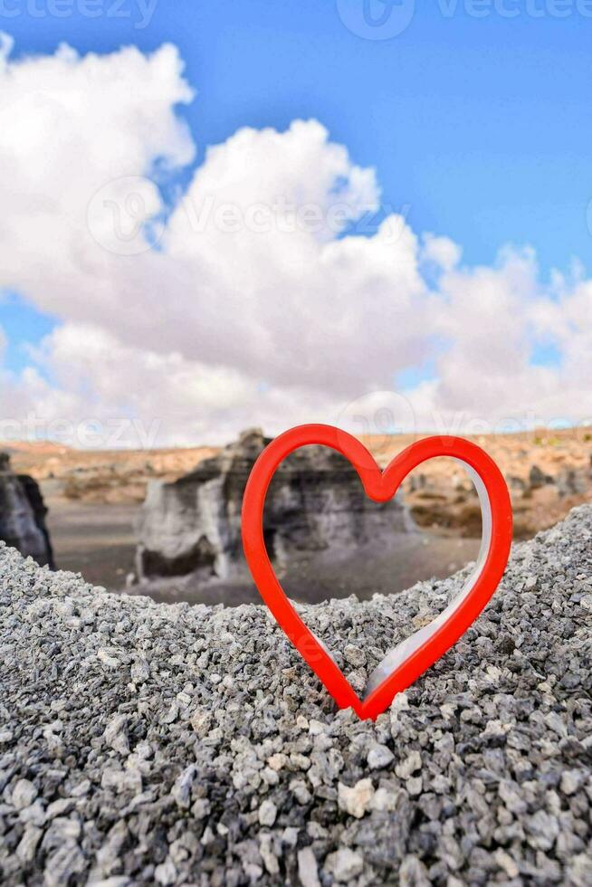 un' cuore sagomato metallo oggetto su un' roccioso scogliera foto