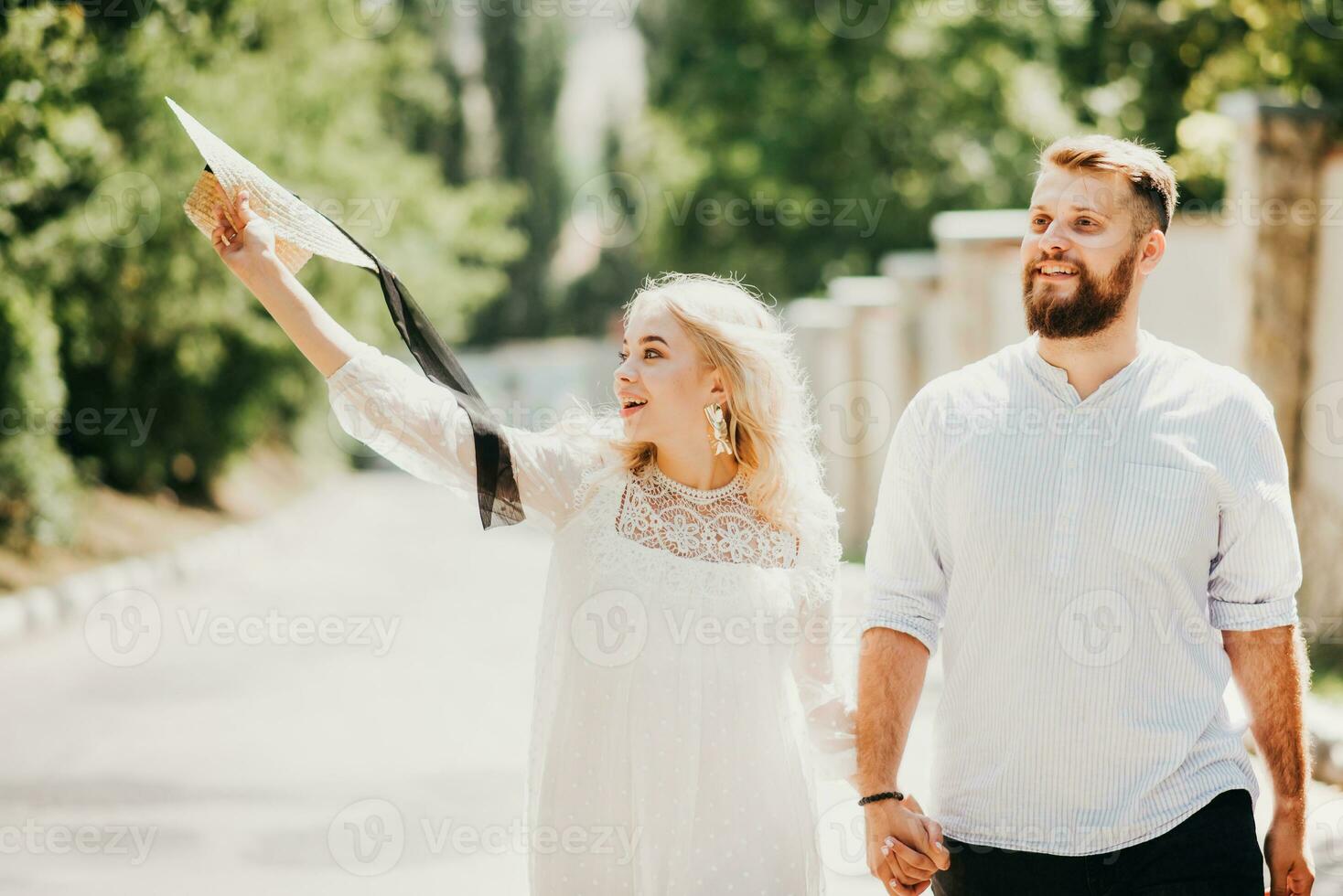 contento e ridendo uomo e donna Tenere mani a piedi lungo il strada su un' soleggiato giorno foto